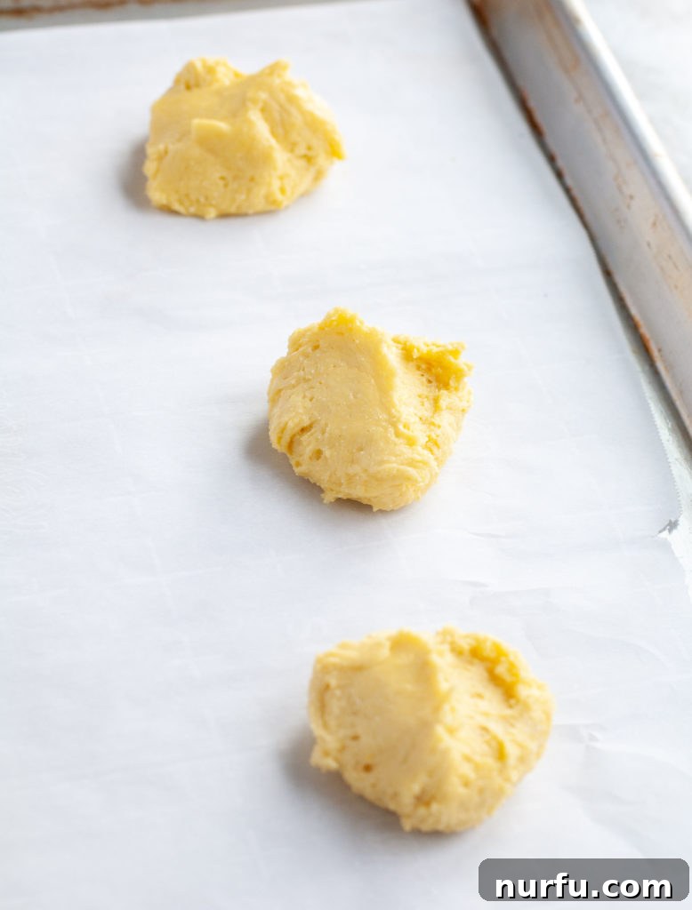 Lemon Cake Mix Cookie Dough Lemon cookie dough neatly portioned on a parchment-lined baking sheet, ready for the oven.