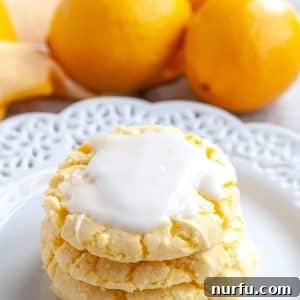 Stack of Lemon Cake Mix Cookies on a plate, glistening with glaze.