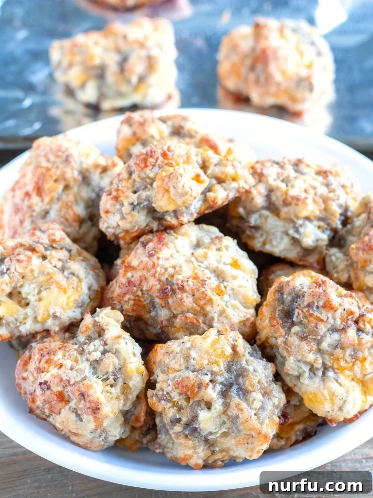 Quick 3 Ingredient Bisquick Sausage Bites 4 A serving plate generously filled with perfectly golden-brown Bisquick Sausage Balls, stacked and ready to be enjoyed.
