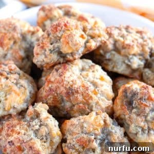 A close-up of a bowl filled with golden-brown, baked Bisquick Sausage Balls, ready for serving.