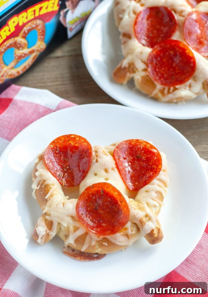 Warm, soft pretzel pizza topped with melted cheese and pepperoni, ready to be dipped.