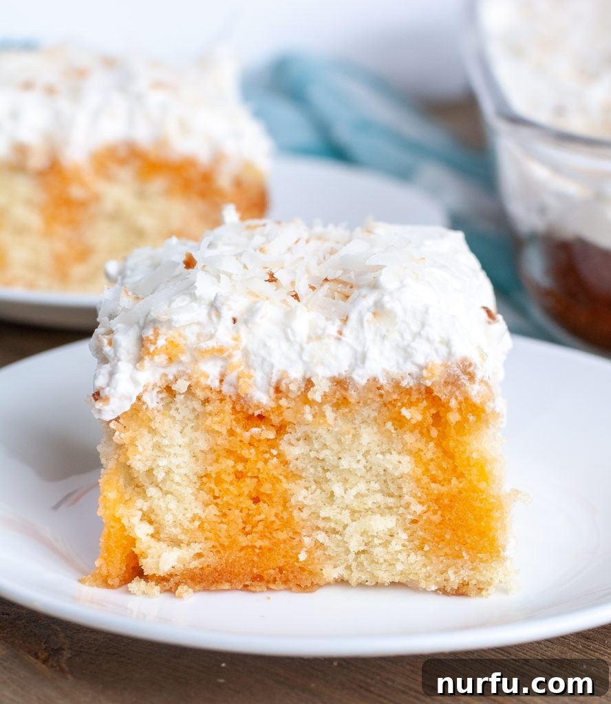 Piece of orange poke cake on a plate