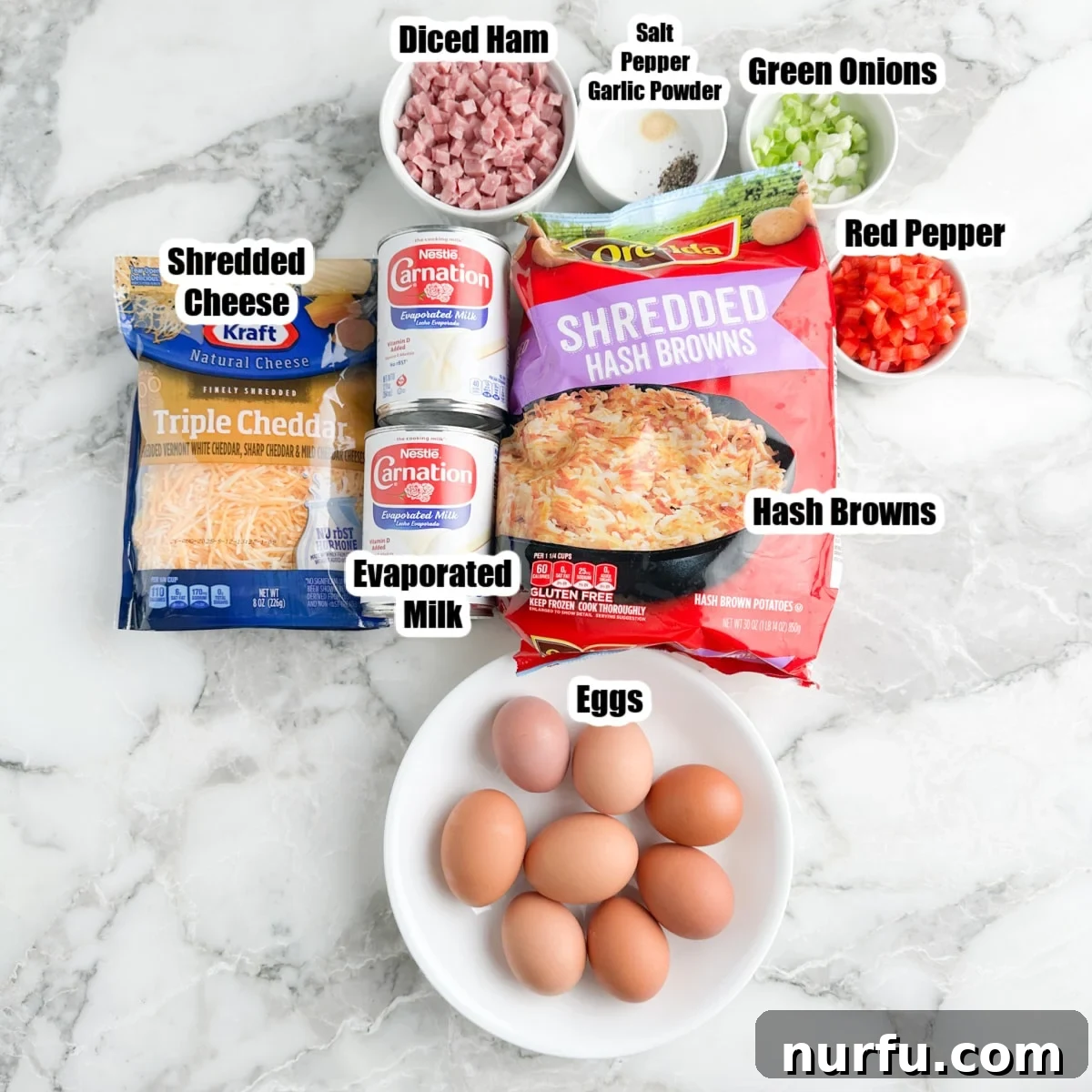 Hearty Farmhouse Casserole 2 A vibrant flat lay of fresh Farmers Casserole ingredients including a bag of hash browns, eggs, cheddar cheese, diced ham, evaporated milk, red bell peppers, and green onions.