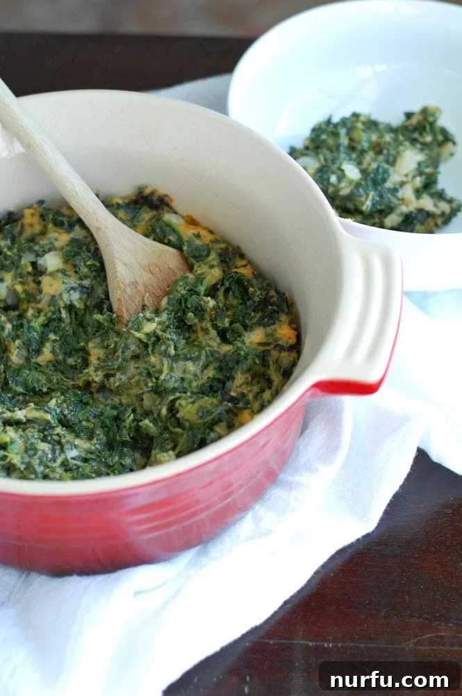 Deviled spinach A close-up of the baked spinach casserole in a red dish, showing its bubbly, golden-brown top and creamy interior.