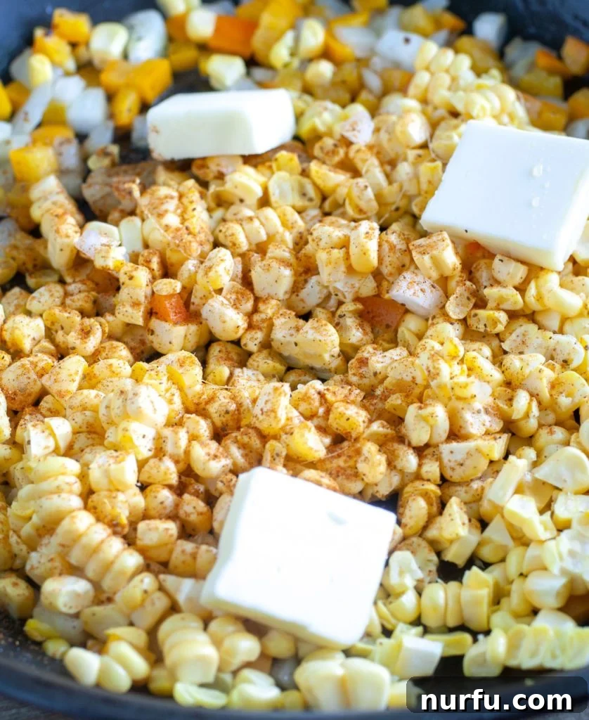 Fried Corn Golden corn kernels with melted butter and sprinkled Cajun seasoning glistening in a hot skillet, ready for the final touches