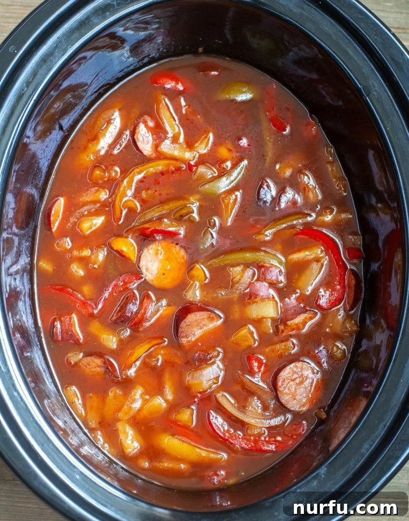 Sweet and Sour Crockpot Kielbasa Freshly cooked Sweet and Sour Crockpot Kielbasa, simmering in the slow cooker with tender vegetables and a rich sauce, ready to be served.