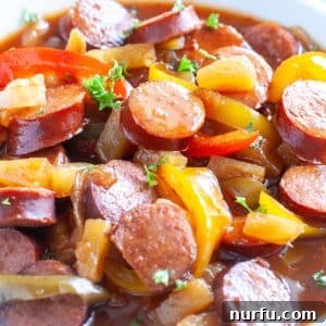 Sweet and Sour Crockpot Kielbasa A beautifully presented bowl of sweet and sour kielbasa with colorful peppers, onions, and pineapple, perfect for a family dinner.
