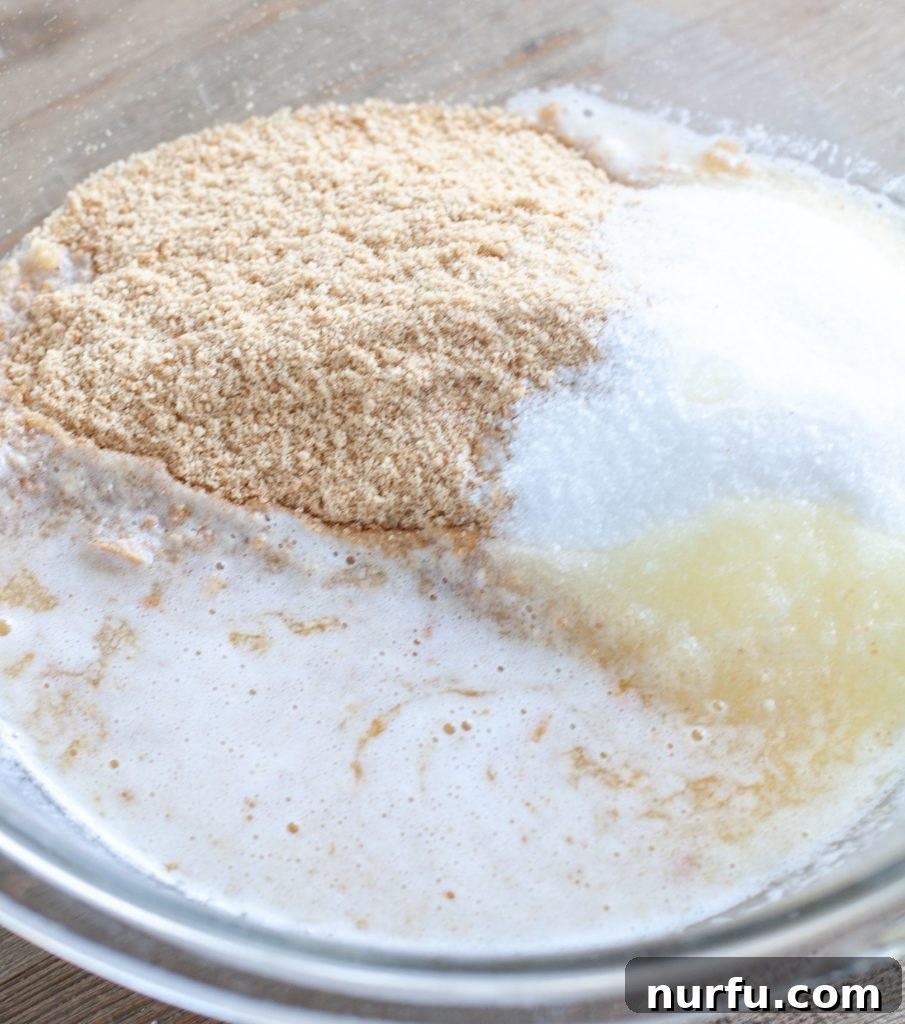 Key Lime Trifle A bowl containing a mixture of crushed graham crackers, melted butter, and sugar, ready for layering.