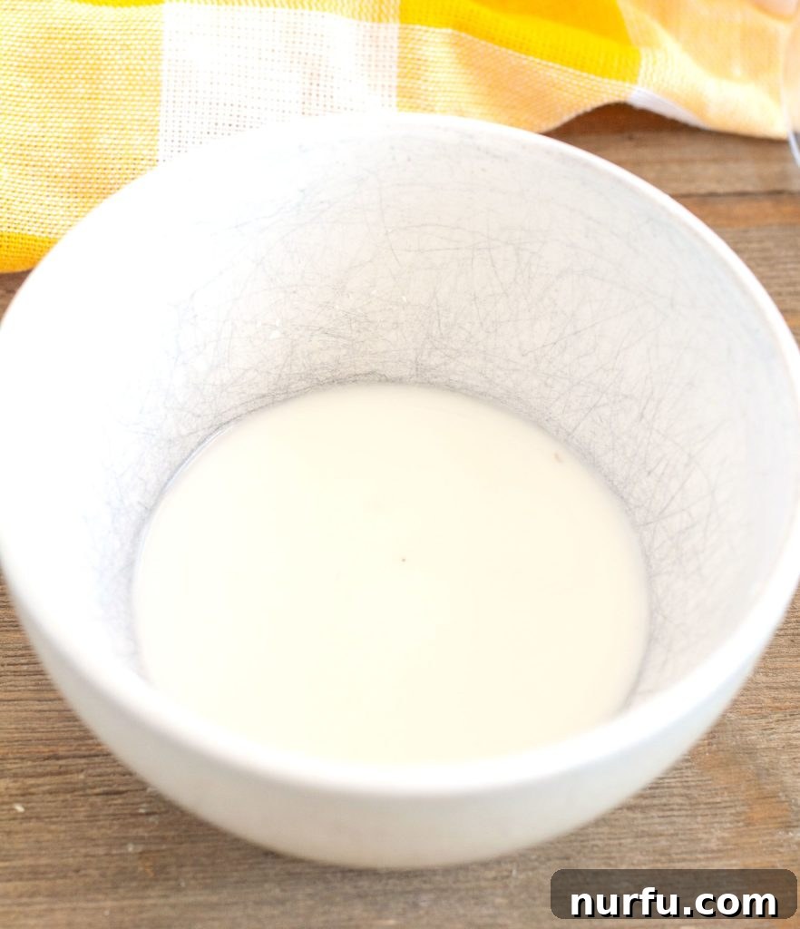 Cornstarch Slurry for Thickening A small bowl containing a cornstarch and water mixture, ready to thicken the apple filling.