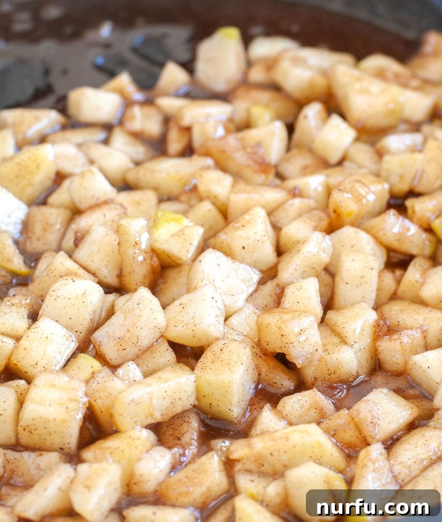 Apple Pie Filling Simmering A saucepan filled with glistening homemade apple pie filling, simmering gently on the stove.