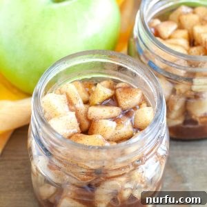 Cooked Apple Pie Filling A glass jar brimming with cooked apple pie filling.