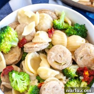 Bowl with sausage, pasta and broccoli.