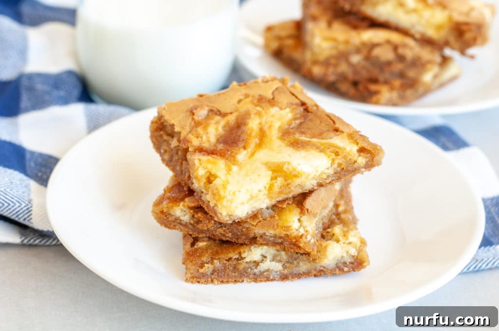 Cream cheese swirled blondies Plate with three cream cheese swirled blondies stacked