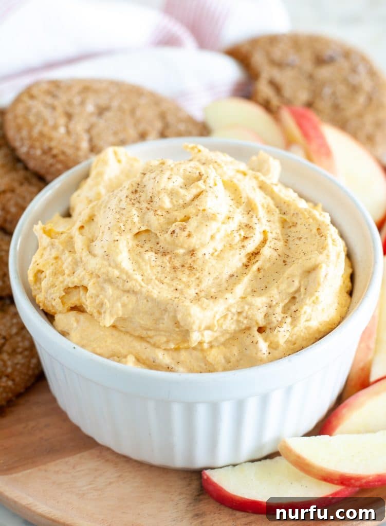 Velvety Pumpkin Spice Dip 2 A beautifully presented bowl of creamy pumpkin dip, artfully garnished and ready to be served with an array of dippers.