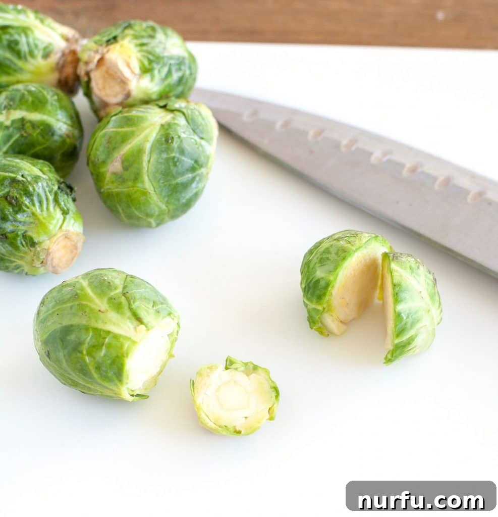 Prepping Brussels Sprouts for Air Frying Fresh Brussels sprouts on a cutting board, neatly trimmed and halved, ready for seasoning.