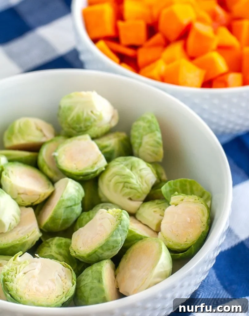 Prepared Brussels Sprouts and Butternut Squash Butternut squash cubes and halved Brussels sprouts in separate bowls, fully prepped and ready for seasoning and air frying.