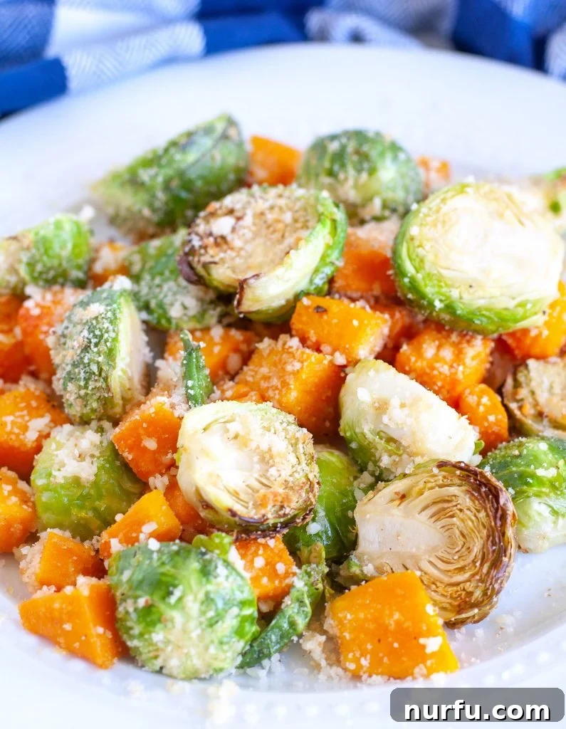 Serving of Air Fryer Roasted Parmesan Vegetables A serving plate generously piled with perfectly roasted Parmesan Brussels sprouts and butternut squash, garnished and ready to be enjoyed as a gourmet side dish.