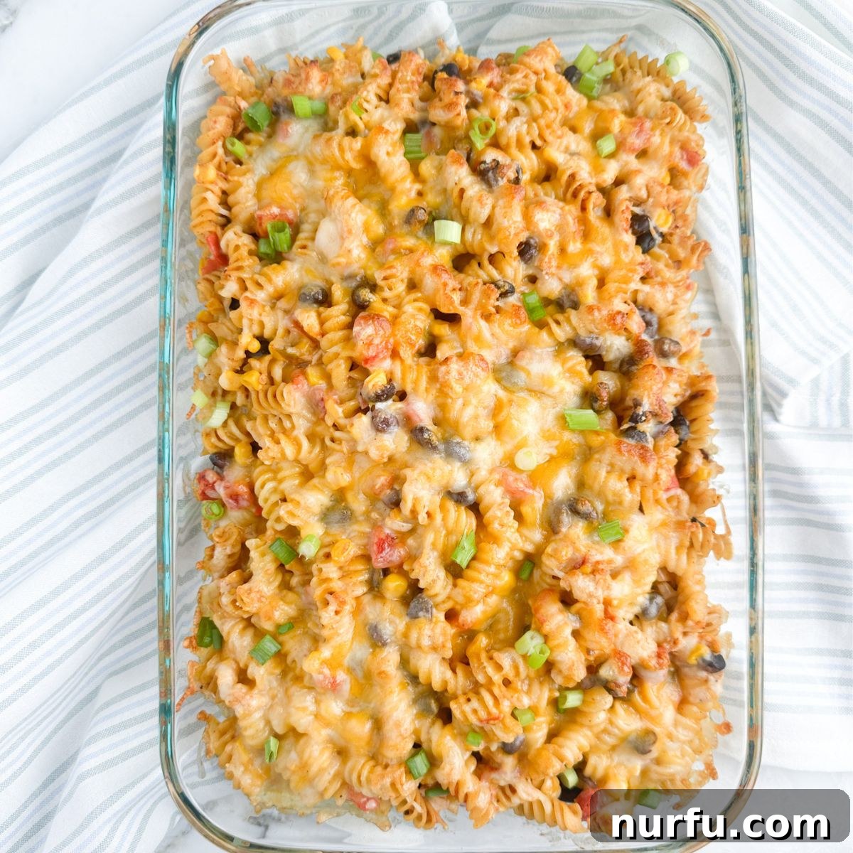 Celebration Chicken Bake 8 Baked casserole dish with a bubbling chicken and pasta casserole, fresh out of the oven.