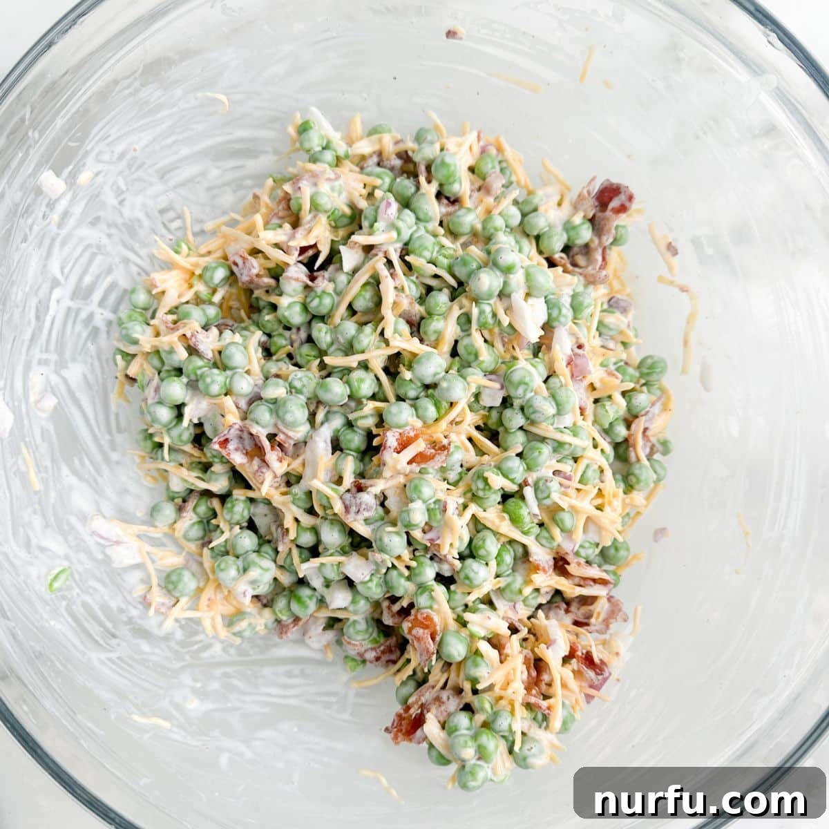 Quick and Creamy Pea Salad 4 A bowl of freshly prepared, creamy pea salad, with all ingredients perfectly coated in the dressing, ready to be chilled and served.