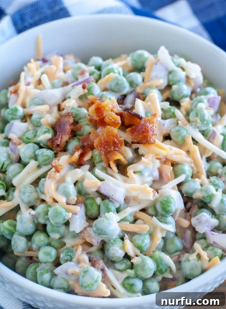 Easy Pea Salad with Bacon Close-up of a delightful pea salad in a bowl, generously topped with an extra sprinkle of crispy crumbled bacon, showcasing its inviting texture and rich ingredients.