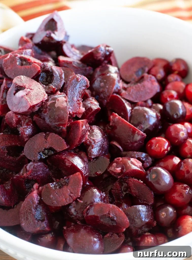 Cranberry Cherry Dump Cake A vibrant bowl filled with fresh cranberries and cherries, showcasing the beautiful colors of the fruits before they are prepared for the dump cake.
