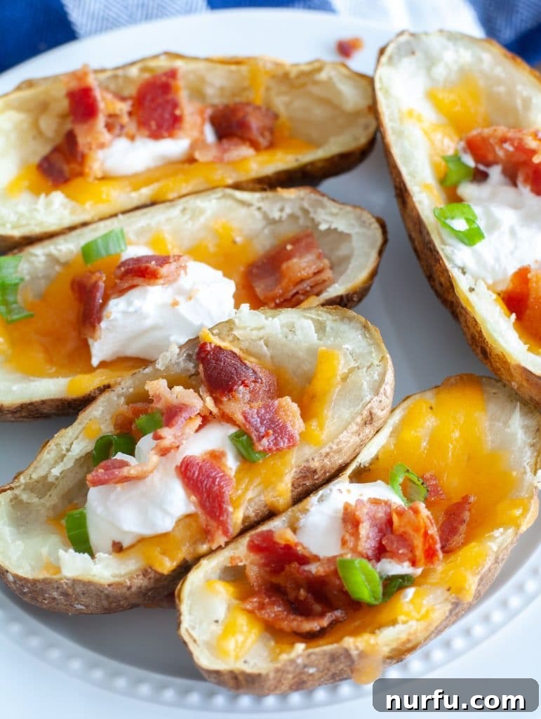 Ultimate Air Fryer Potato Skins 2 Plate of air fryer potato skins loaded with sour cream, cheese and bacon.