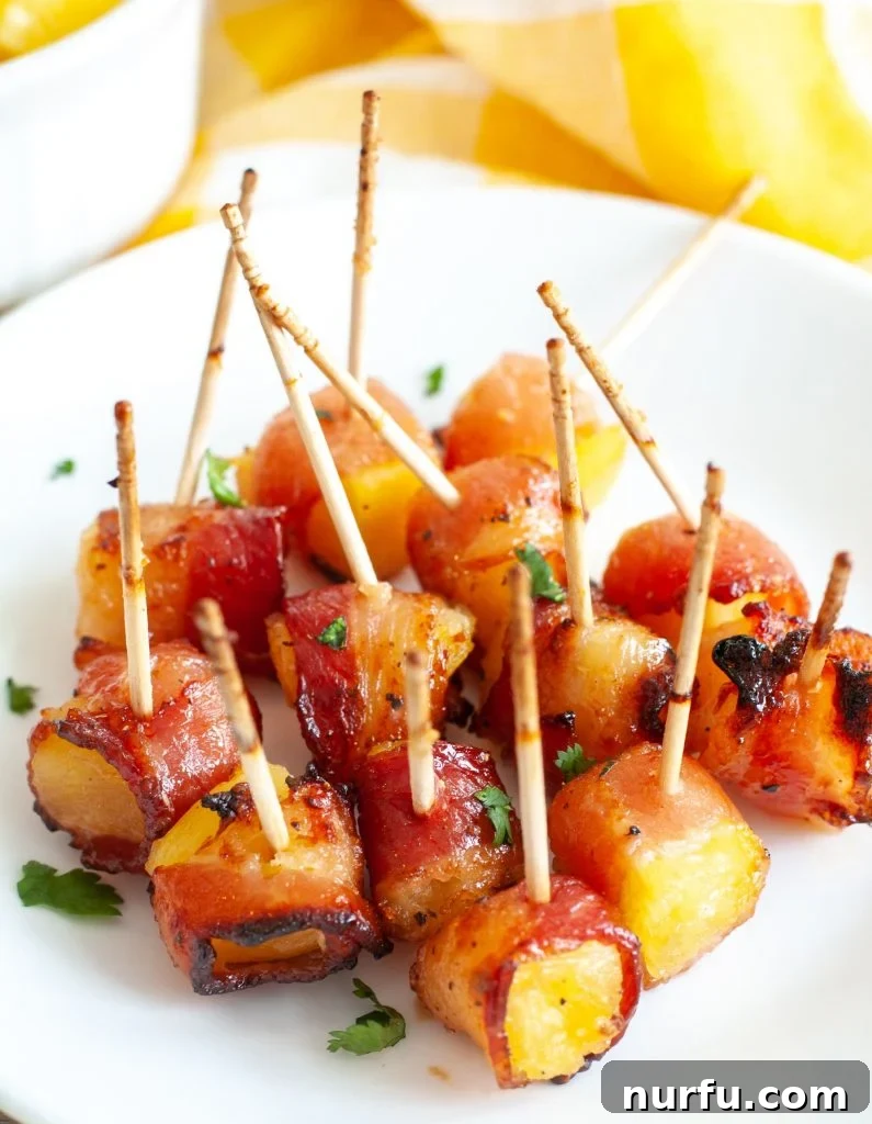 Plate of perfectly cooked bacon wrapped pineapple appetizers, ready to be served