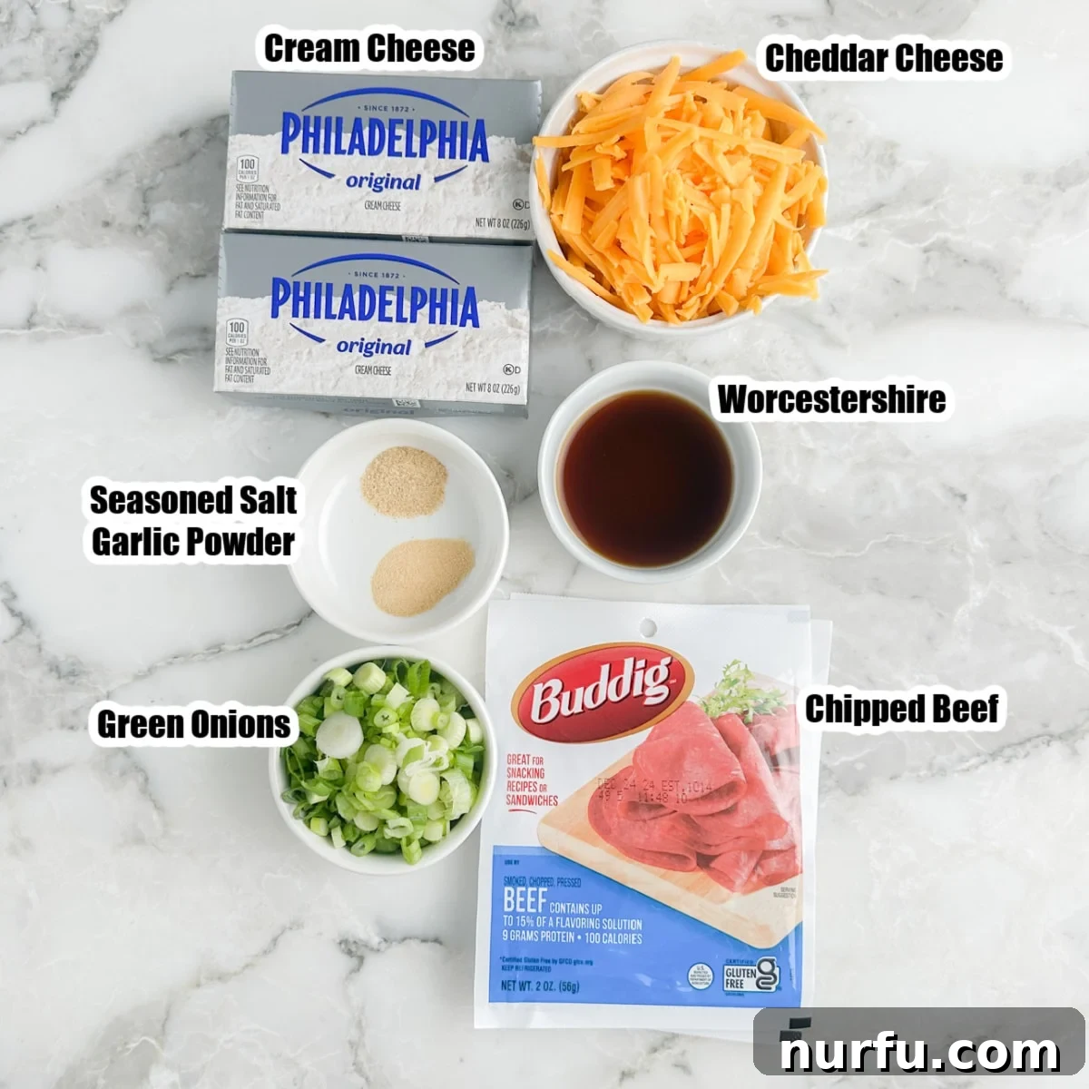 Signature Chipped Beef Cheese Ball 3 Close-up of key ingredients for Chipped Beef Cheese Ball: softened cream cheese blocks, a bowl of shredded cheddar, chopped chipped beef, fresh green onions, and bottles of Worcestershire sauce and seasoning.