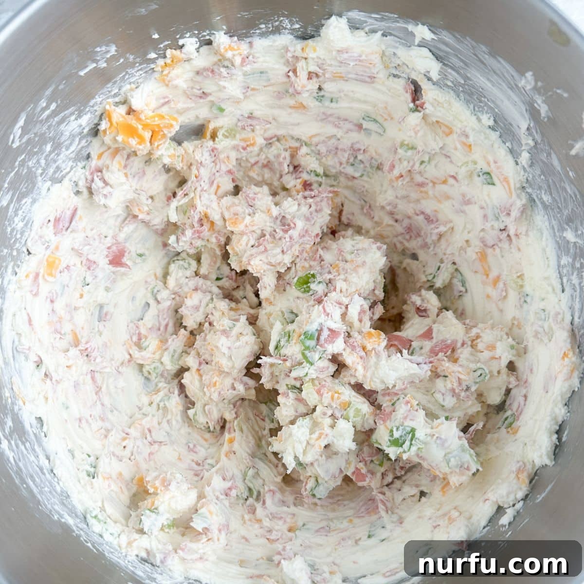 Signature Chipped Beef Cheese Ball 5 Close-up of a mixing bowl with a creamy, well-combined chipped beef cheese ball mixture, showcasing the integrated ingredients.