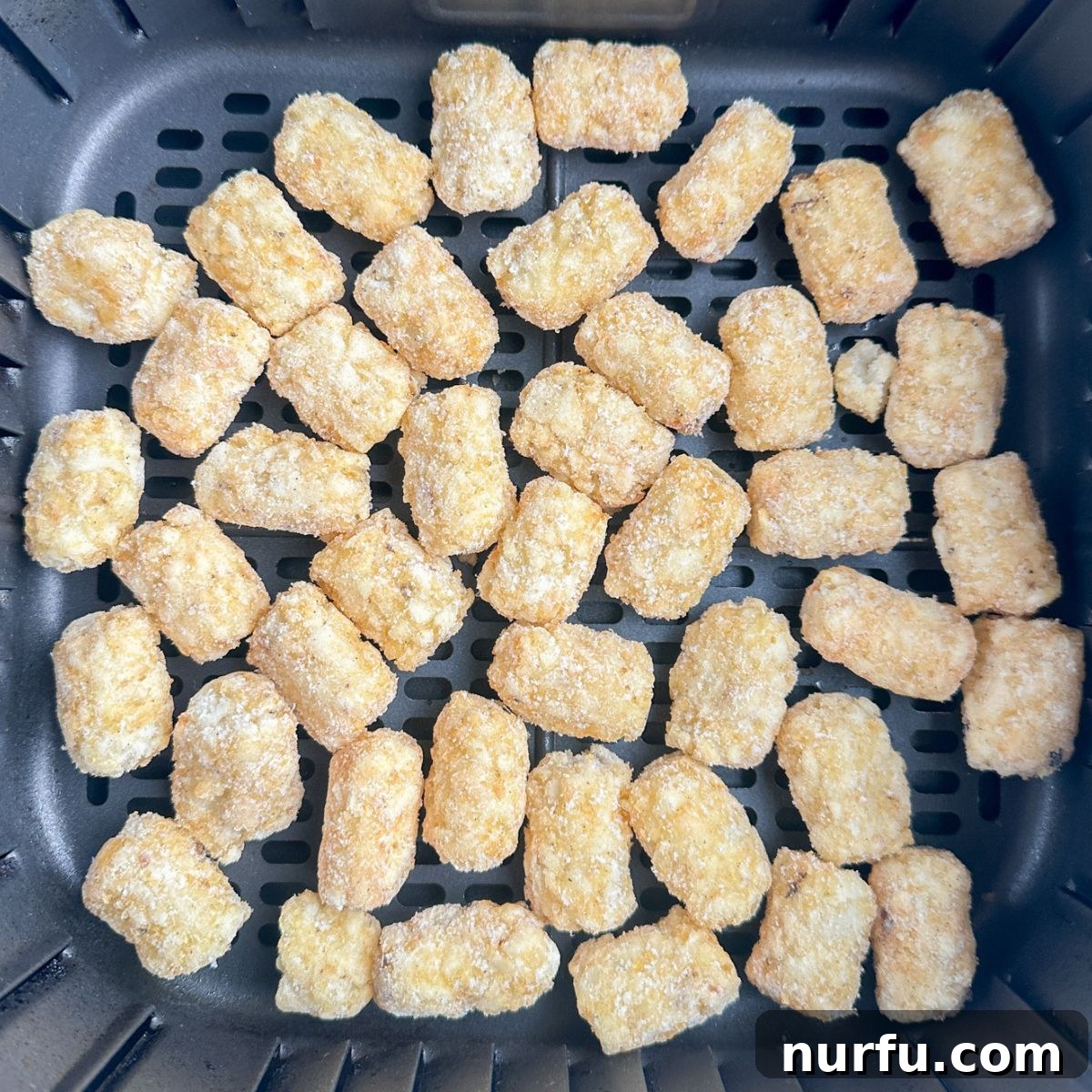 Golden Crispy Air Fryer Tots 4 Air fryer basket filled with frozen tater tots before cooking