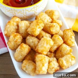 Golden Crispy Air Fryer Tots 7 Tator Tots on a plate with bowl of ketchup.