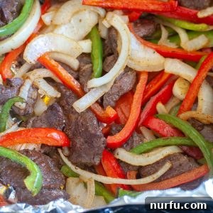Steak, peppers and onions in foil.