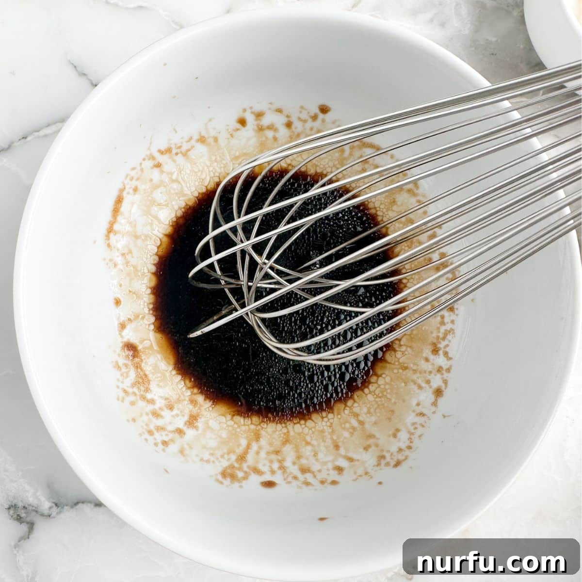Savory Ground Beef Ramen 6 Bowl of soy sauce with a whisk.