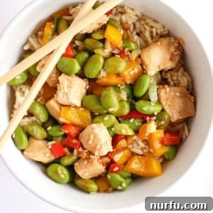 Chicken and edamame in bowl with chopsticks.