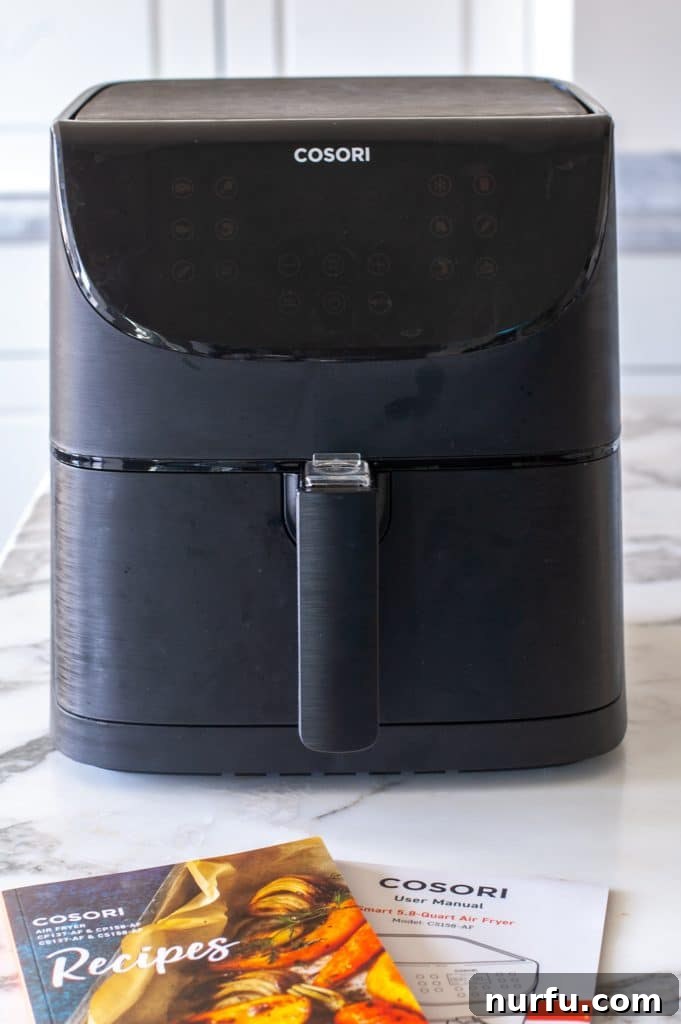 Cosori Air Fryer: Is It Worth Buying 2 A sleek Cosori air fryer positioned prominently on a wooden kitchen table, ready for cooking.