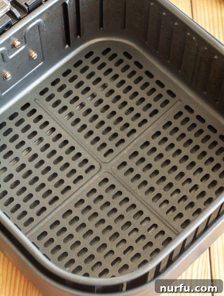 Cosori Air Fryer: Is It Worth Buying 4 The durable, non-stick interior of the Cosori air fryer's basket and crisper plate, ready for use or easy cleaning.