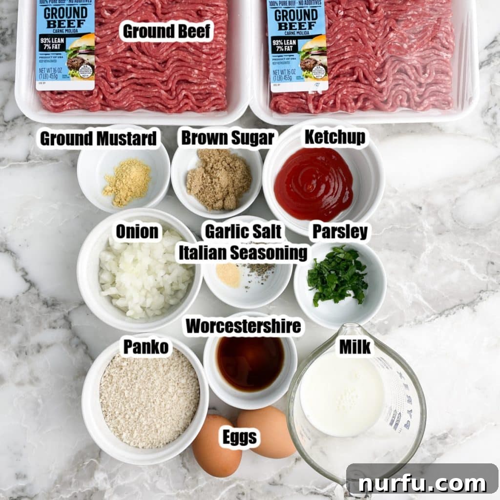 A flat lay photograph of all the air fryer meatloaf ingredients: ground beef, bowls of spices, ketchup, diced onion, panko bread crumbs, eggs, and a glass of milk, arranged neatly on a wooden surface.
