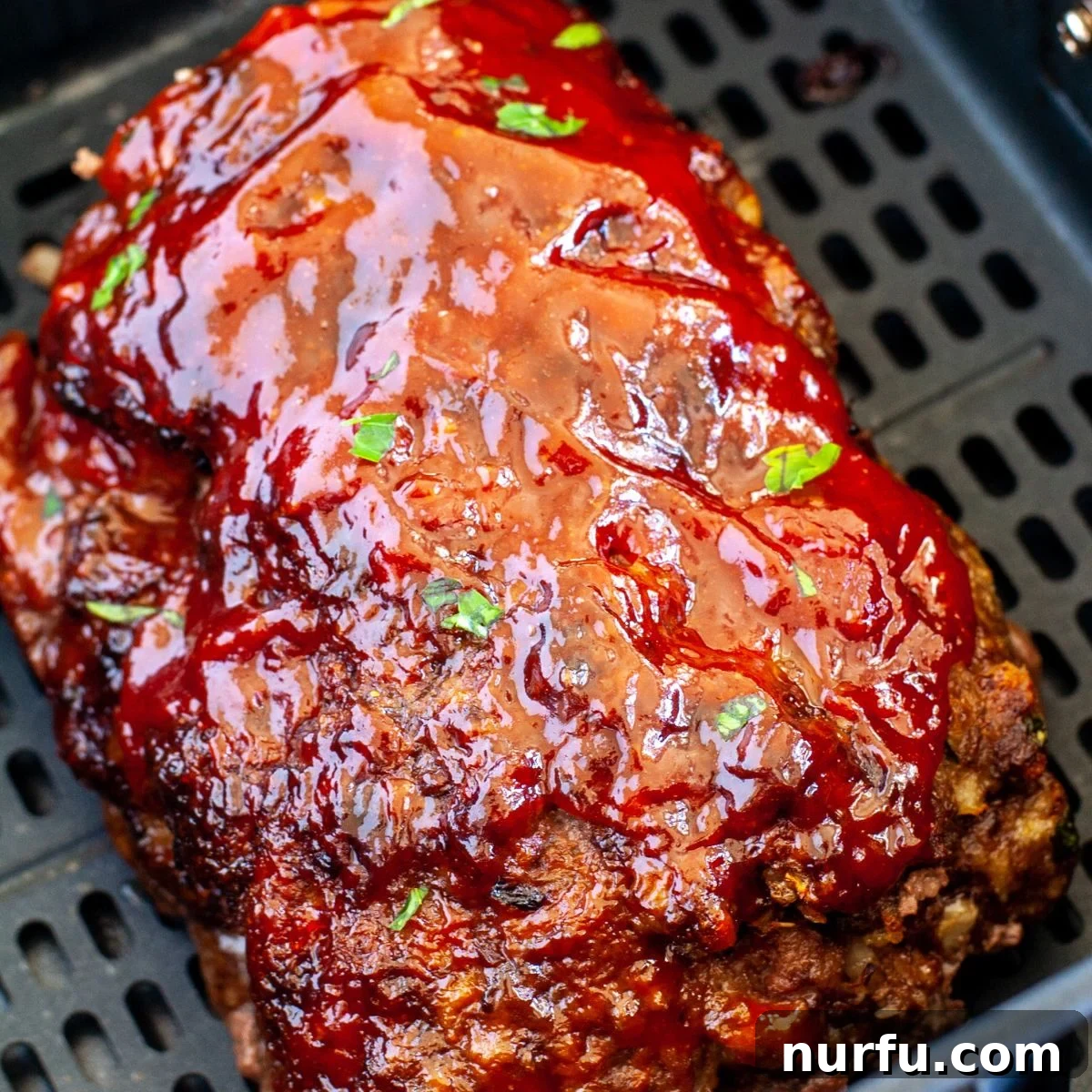 A freshly cooked air fryer meatloaf, sliced and beautifully presented on a cutting board, ready to be served, showcasing its moist interior.