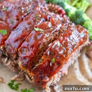 Cooked air fryer meatloaf with sauce, sliced and ready to serve.