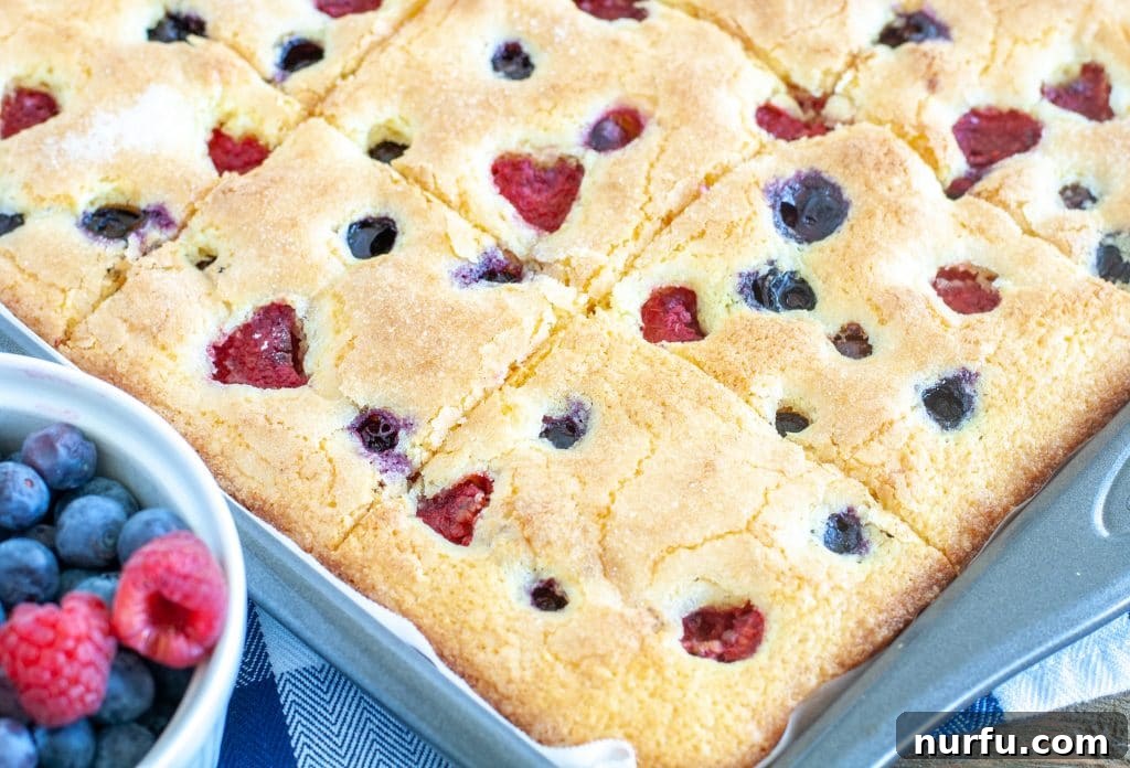 A golden-brown cornmeal sheet cake in a baking pan, fresh from the oven, showing its perfect crust and texture.