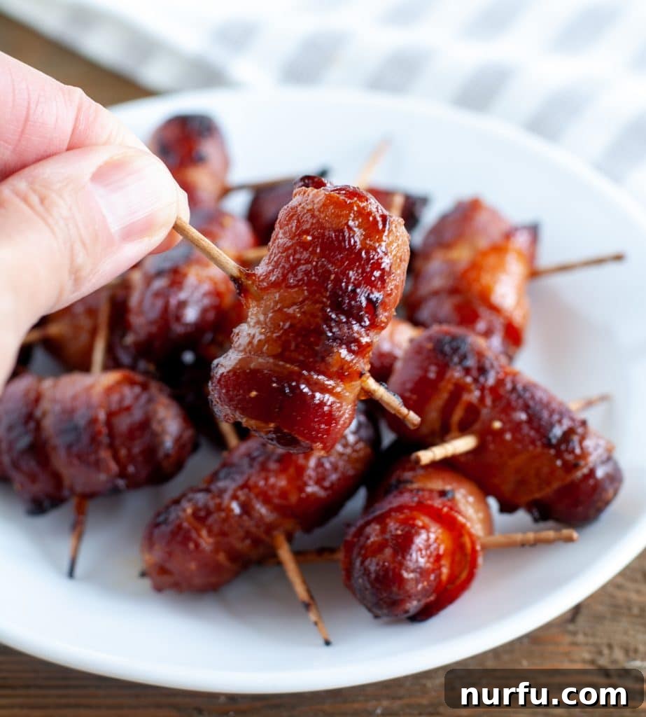 Crispy Air Fryer Piggy Wraps 5 hand holding bacon wrapped smokie