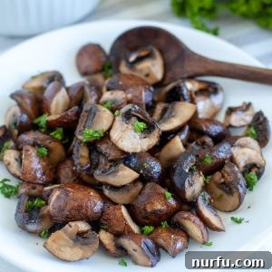 Cooked mushrooms on plate with spoon.