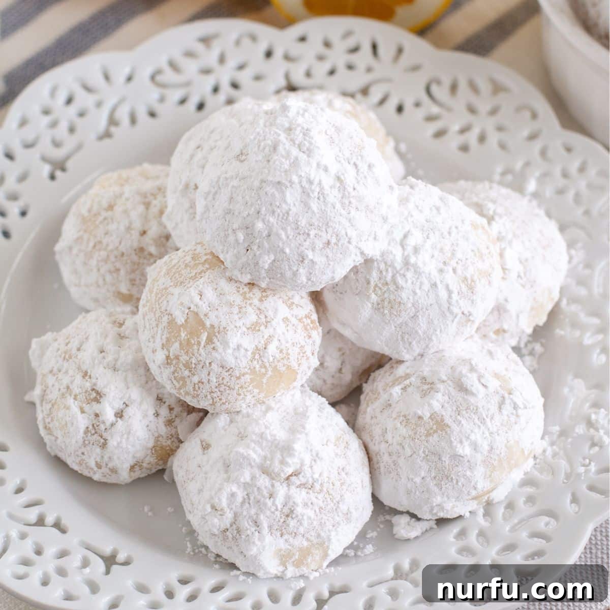 Powdered Lemon Puffs 5 Plate of powdered sugar lemon snowball cookies, ready to be enjoyed.