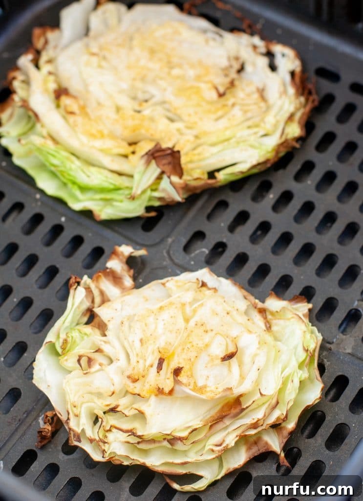 Crispy Air Fryer Cabbage 5 Roasted cabbage wedges in an air fryer basket.