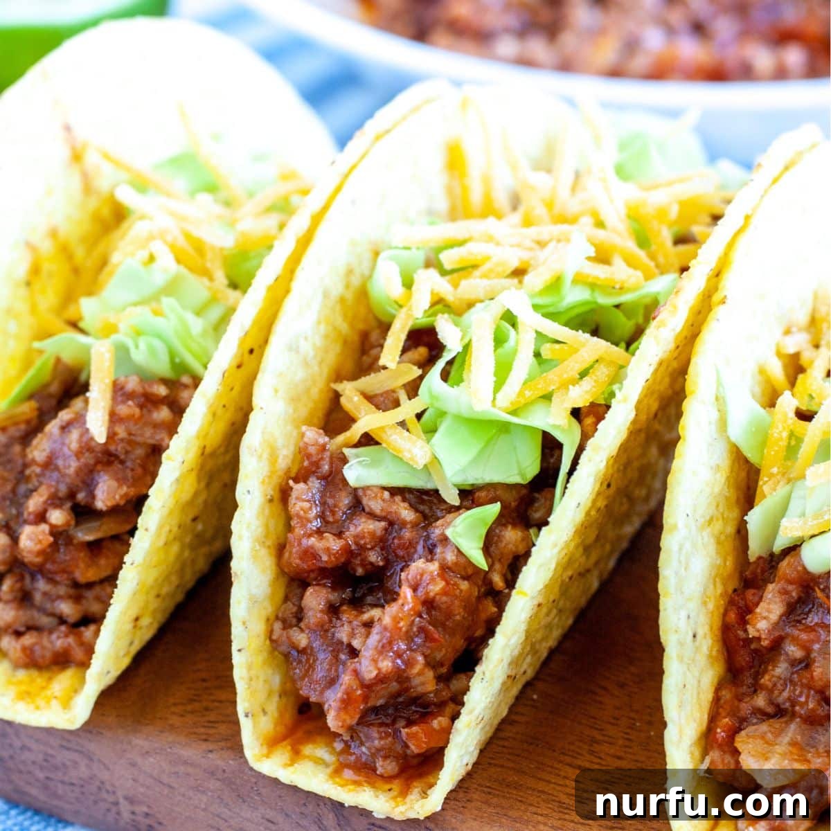 Effortless Slow Cooker Tacos 2 Hard shell beef tacos garnished with fresh cilantro and cheese.
