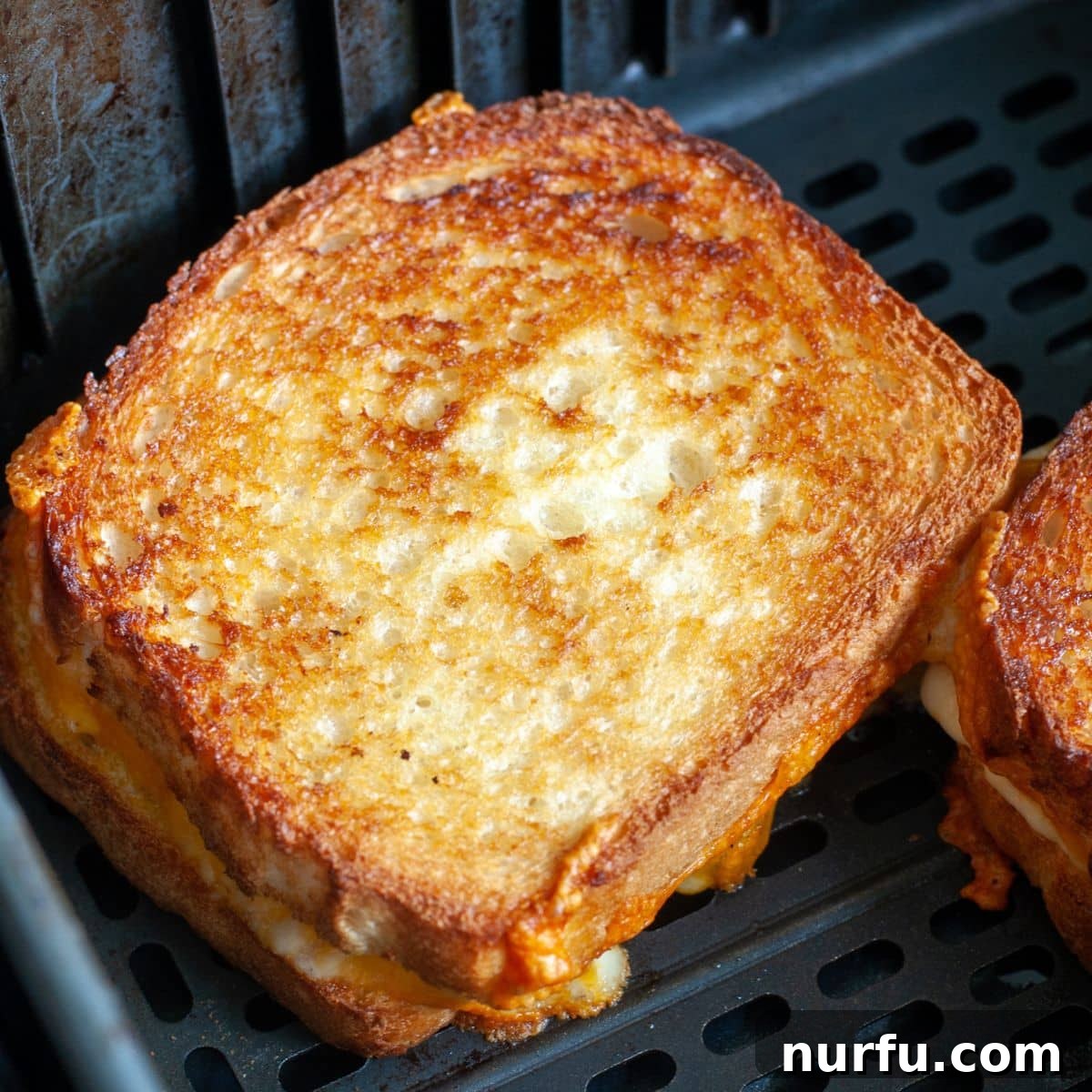 Crispy Air-Fried Cheese Toastie 6 A freshly air-fried grilled cheese sandwich, golden and delicious, resting in an air fryer basket.