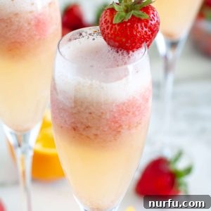 Strawberry Mimosa in a glass with a strawberry garnish