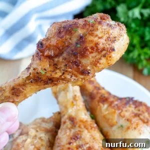 Hand holding chicken leg.