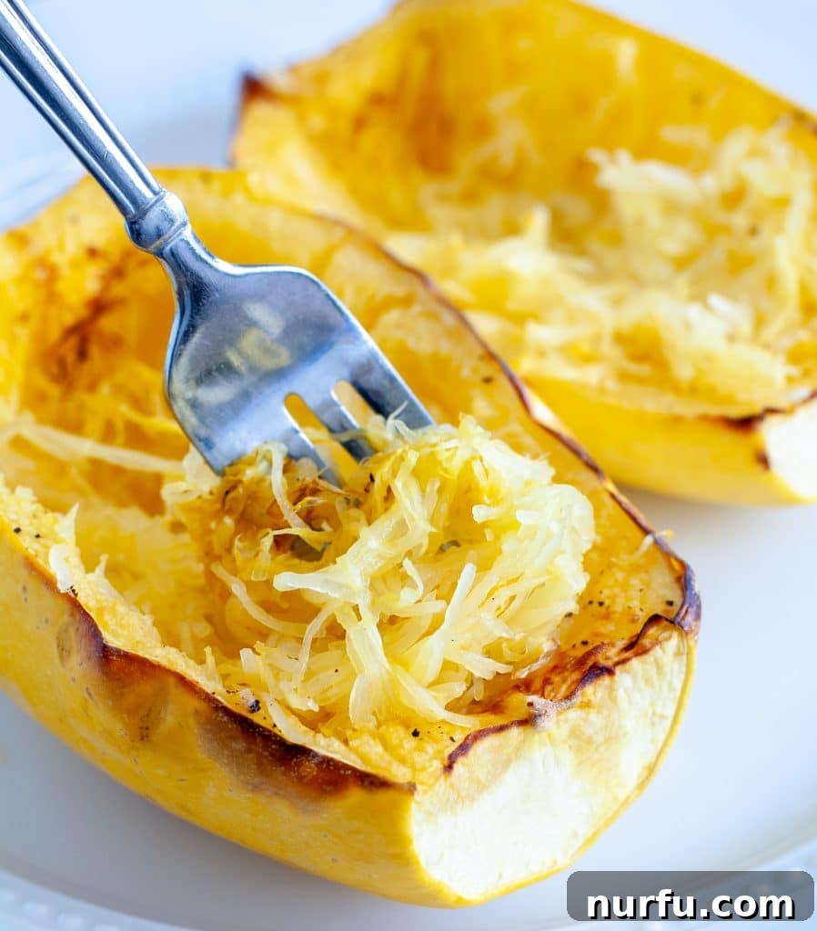 Crispy Air Fryer Spaghetti Squash 2 Perfectly cooked spaghetti squash served on a plate with a fork, ready to be enjoyed as a healthy and delicious meal.
