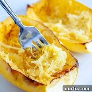 Cooked spaghetti squash with a fork, ready to be served and enjoyed as a healthy meal.